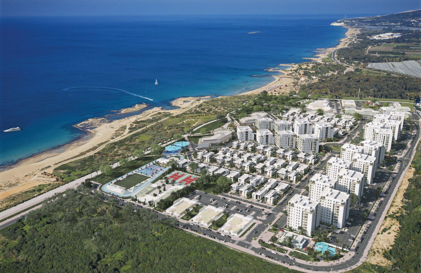 הדמיית תכנון אווירית של שכונת מגורים על קו החוף באכזיב, עם בניינים, בריכות וחוף ים ברקע